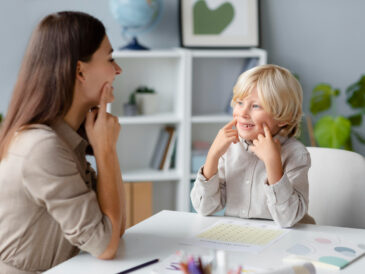 Orthophoniste accompagnant un enfant lors d’exercices d’articulation et de rééducation du langage en cabinet