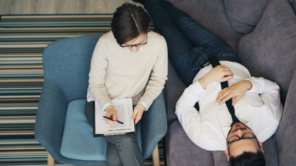 Psychiatre en séance d’écoute avec un patient allongé sur un divan