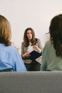 Coach professionnelle animant un atelier de développement personnel devant un groupe