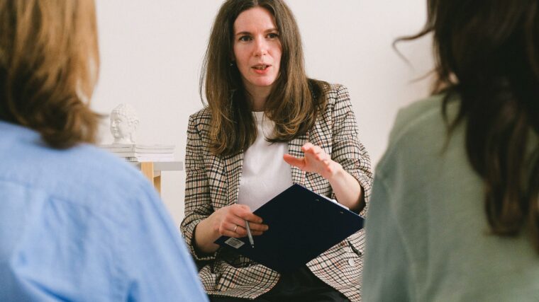 Coach professionnelle animant un atelier de développement personnel devant un groupe