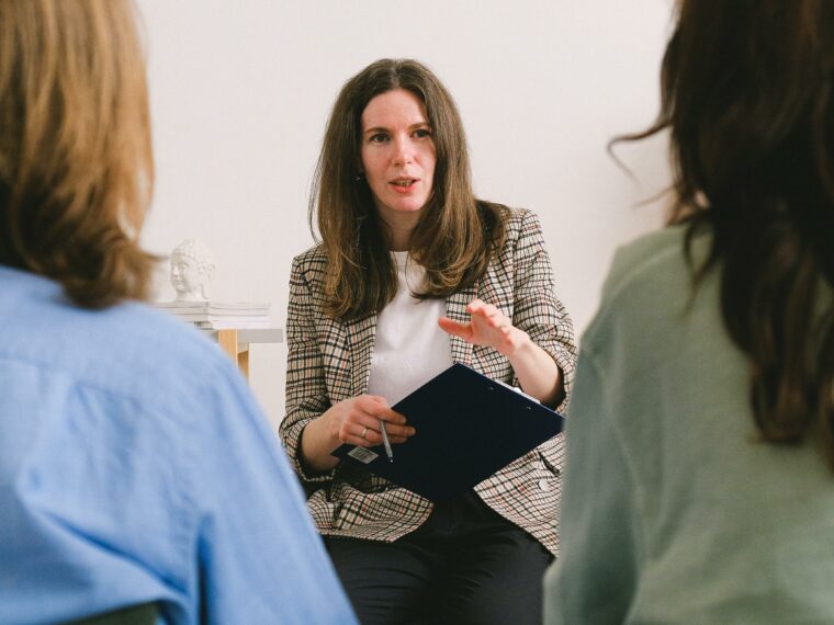 Coach professionnelle animant un atelier de développement personnel devant un groupe