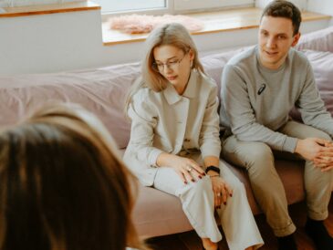 Sexologue recevant un couple en consultation dans un cabinet professionnel