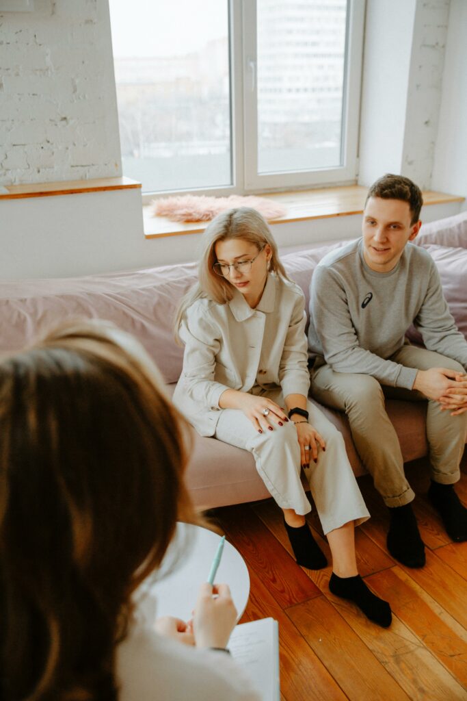 Sexologue recevant un couple en consultation dans un cabinet professionnel