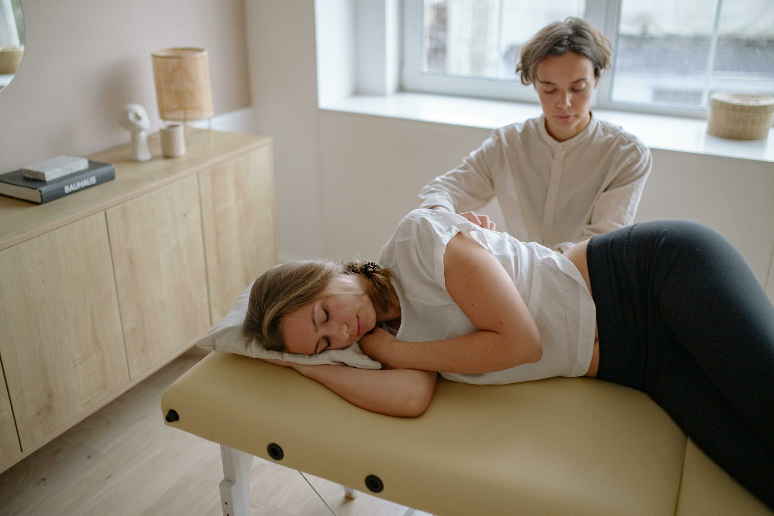 Chiropracteure réalisant une séance de soins manuels avec une patiente en cabinet